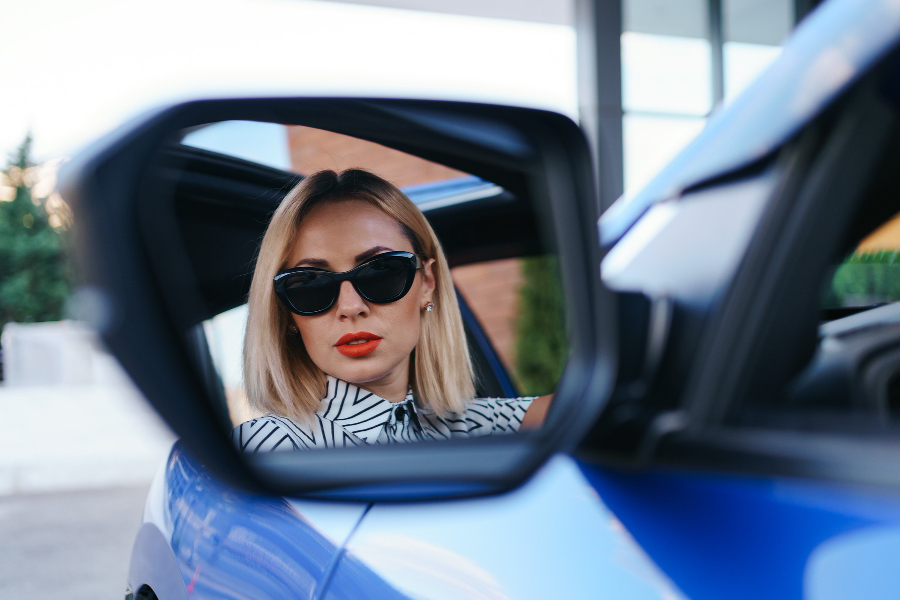 young-woman-driver-looking-car-side-view-mirror-making-sure-line-is-free-before-making-turn (1)